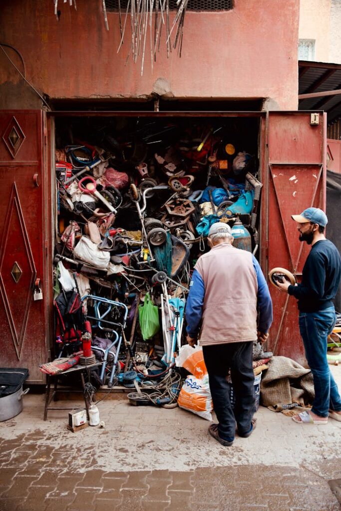 Men Standing in Front of a Storage Full of Trash 